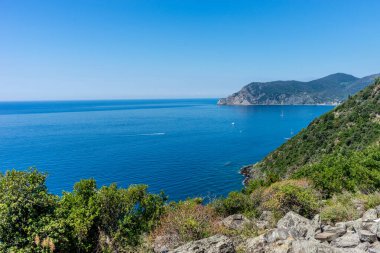 Avrupa, İtalya, Cinque Terre, Corniglia, arkasında dağ olan bir su kütlesi.
