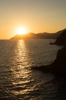 İtalya 'nın Riomaggiore Köyü, Cinque Terre' deki İtalyan Riviera 'sındaki uçurumda altın gün batımı
