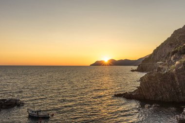 İtalya 'nın Riomaggiore Köyü, Cinque Terre' deki İtalyan Riviera 'sındaki uçurumda altın gün batımı