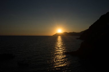 İtalya 'nın Riomaggiore Köyü, Cinque Terre' deki İtalyan Riviera 'sındaki uçurumda altın gün batımı