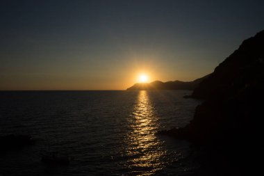 İtalya 'nın Riomaggiore Köyü, Cinque Terre' deki İtalyan Riviera 'sındaki uçurumda altın gün batımı
