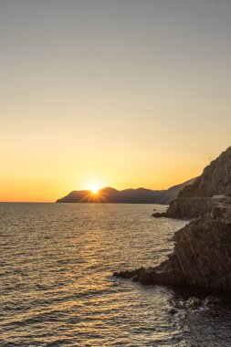 İtalya 'nın Riomaggiore Köyü, Cinque Terre' deki İtalyan Riviera 'sındaki uçurumda altın gün batımı