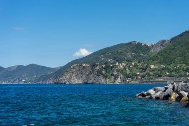Avrupa, İtalya, Cinque Terre, Riomaggiore, arkasında dağ olan büyük bir su kütlesi.
