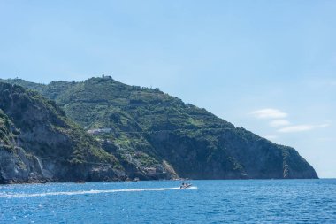 Avrupa, İtalya, Cinque Terre, Riomaggiore, arkasında dağ olan büyük bir su kütlesi.