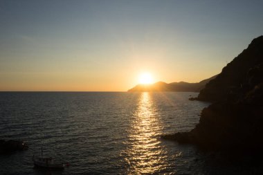 İtalya 'nın Riomaggiore Köyü, Cinque Terre' deki İtalyan Riviera 'sındaki uçurumda altın gün batımı
