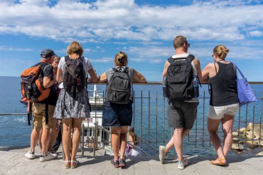 Riomaggiore, Cinque Terre, İtalya - 26 Haziran 2018: Riomaggiore, Cinque Terre, İtalya 'daki Riomaggiore iskelesinde okyanus manzarasını sırılsıklam eden turistler