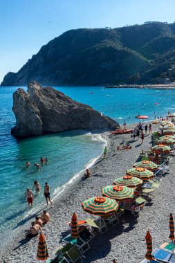 Monterosso, Cinque Terre, Italy - 26 June 2018: Tourists enjoying the beach and sunshine at Monterosso al mare clipart
