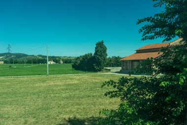 Avrupa, İtalya, La Spezia 'dan Kasltelruth trenine. Arkasında ağaçlar olan büyük yeşil bir alan.