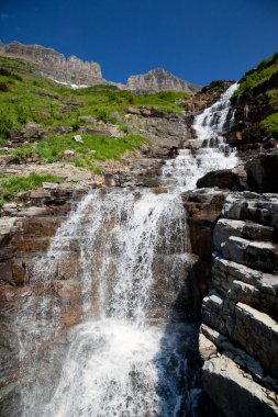Yeşil çim ve şelaleler boyunca güneş yolun buzul Milli Parkı'nda olacak