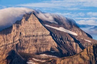Bir battaniye bulutların Glacier Ulusal Parkı, Montana'da bir dağ tepe kapsar