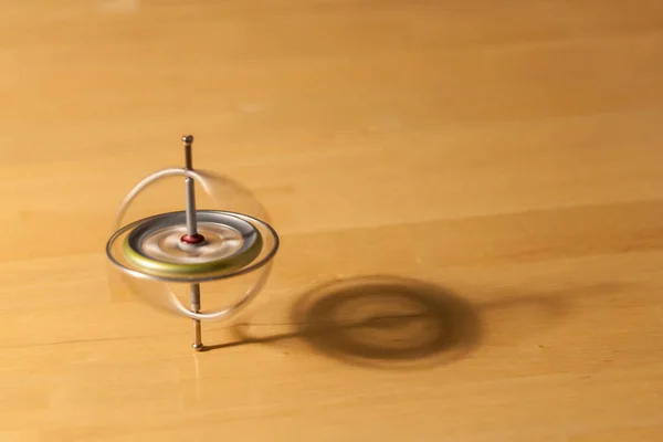 Gyroscope spinning and balancing on a wooden table — Stock Photo, Image