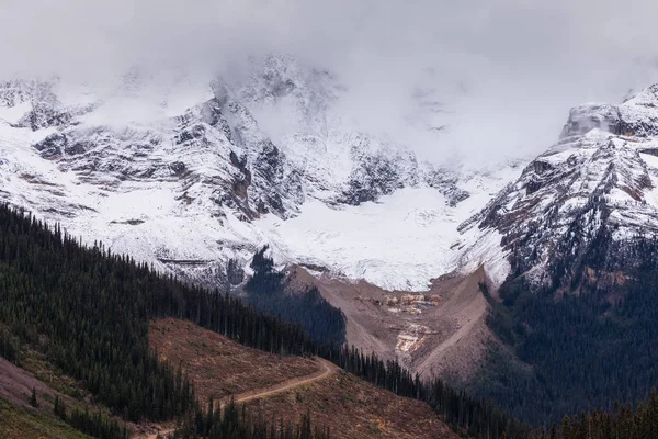 Un montagnard dans les montagnes Rocheuses canadiennes enveloppé de nuages par une journée froide — Photo