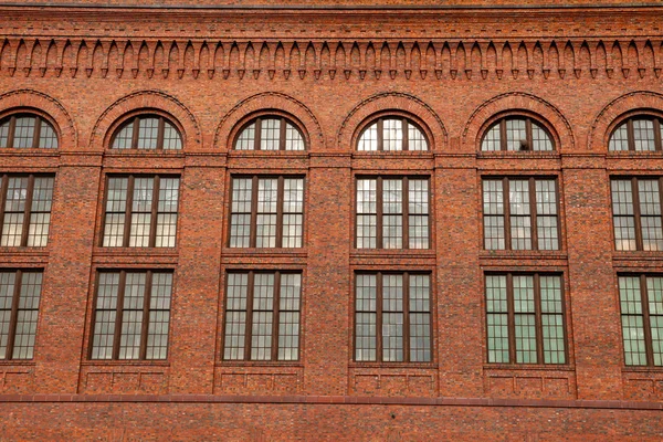 Grandes janelas no lado de um edifício de tijolos vermelhos — Fotografia de Stock