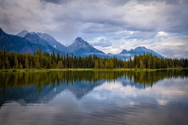 Mountains reflecting in the calm waters of Spillway Lake in Peter Lougheed Provincial Park, Alberta