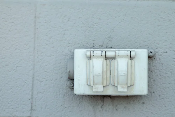 Velho rústico tomada elétrica norte-americana em uma parede de tijolo exterior — Fotografia de Stock