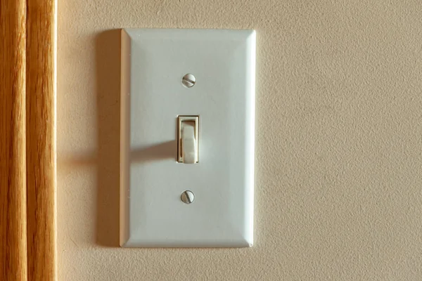 Un interruptor de luz norteamericano en una pared cerca de una puerta —  Fotos de Stock