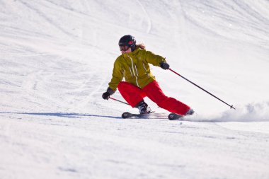 Kanada Rocky Dağları, Alberta bir kayak beldesinde açık bir yamaçta downhill kayak genç kadın