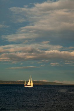Port Townsend, Washington yakınlarında gün batımında suda küçük bir yelkenli