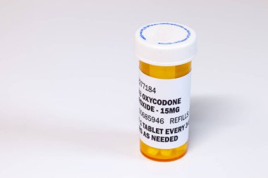 Prescription bottle with Oxycodone tablets isolated on a white background. Oxycodone is a generic prescription opioid. clipart