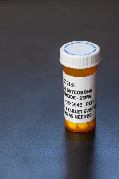 Frasco de prescripción con comprimidos retroiluminados de oxicodona. La oxicodona es un opioide genérico recetado . — Foto de Stock