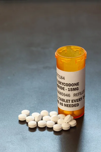 Prescription bottle with backlit Oxycodone tablets. Oxycodone is a generic prescription opioid.