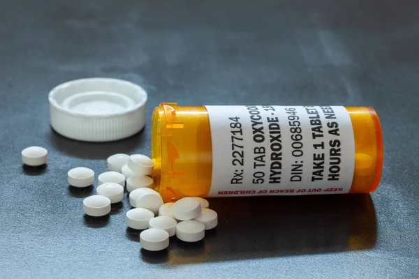 Frasco de prescrição com comprimidos de oxicodona retroiluminados. Oxycodone é um opioide de prescrição genérica . — Fotografia de Stock