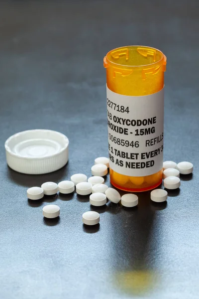 Prescription bottle with backlit Oxycodone tablets. Oxycodone is a generic prescription opioid.