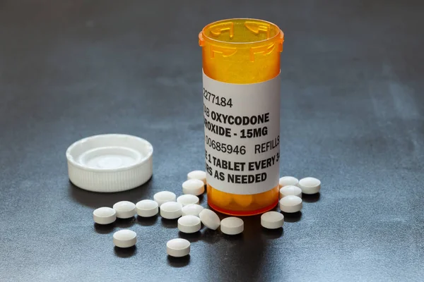 Prescription bottle with backlit Oxycodone tablets. Oxycodone is a generic prescription opioid.