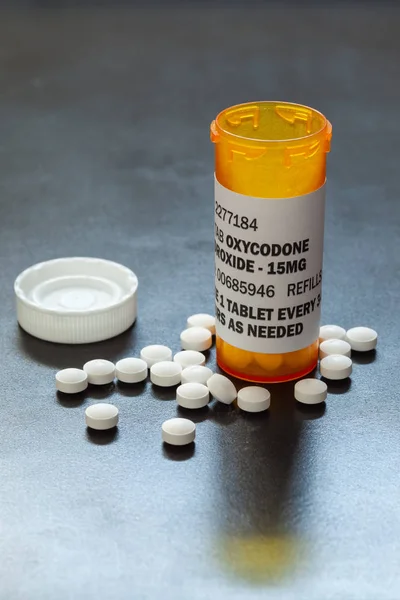 Frasco de prescripción con comprimidos retroiluminados de oxicodona. La oxicodona es un opioide genérico recetado . — Foto de Stock