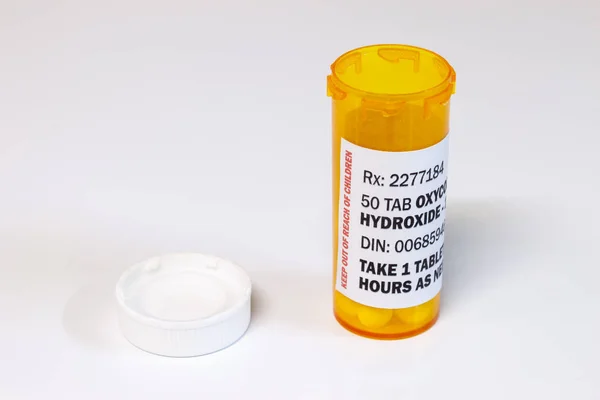Frasco con comprimidos de oxicodona aislados sobre fondo blanco. La oxicodona es un opioide genérico recetado . — Foto de Stock