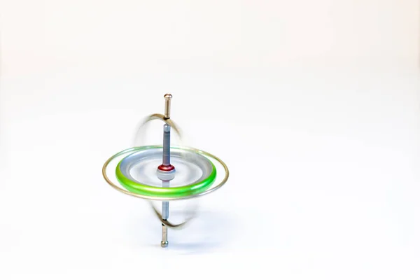 Un giroscopio de juguete giratorio aislado sobre un fondo blanco —  Fotos de Stock