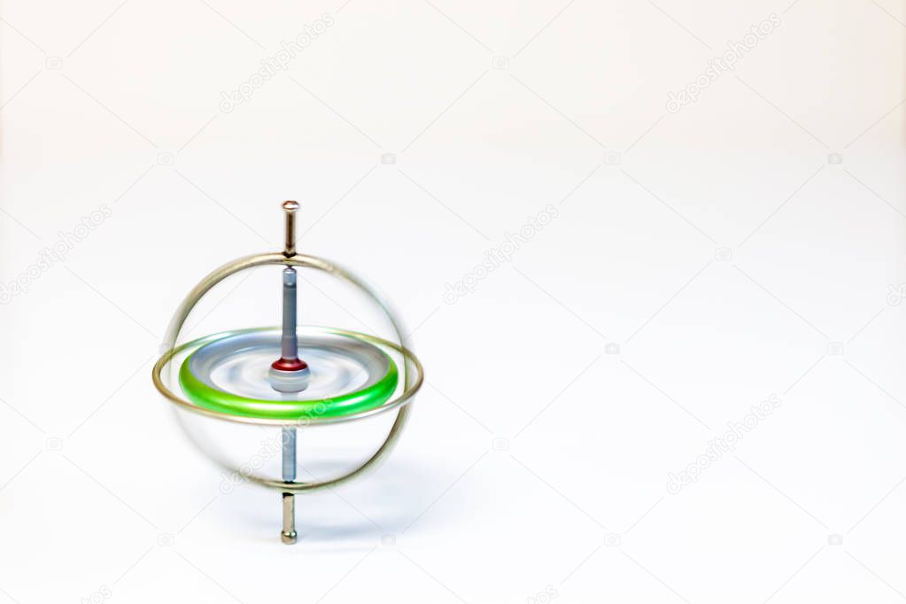 A spinning metal toy gyroscope isolated on a white background