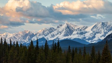 Kananaskis Country, Alberta'da bir dağ sırası üzerinde gün doğumunda karamsar bir gökyüzü