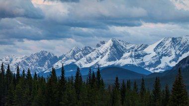 Kananaskis Country, Alberta'da bir sıradağların üzerinde karamsar bir gökyüzü