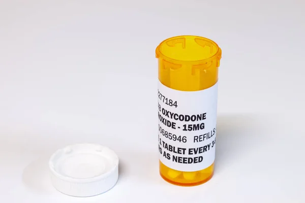 Frasco de prescrição com comprimidos de oxicodona isolados sobre fundo branco. Oxycodone é um opioide de prescrição genérica . — Fotografia de Stock