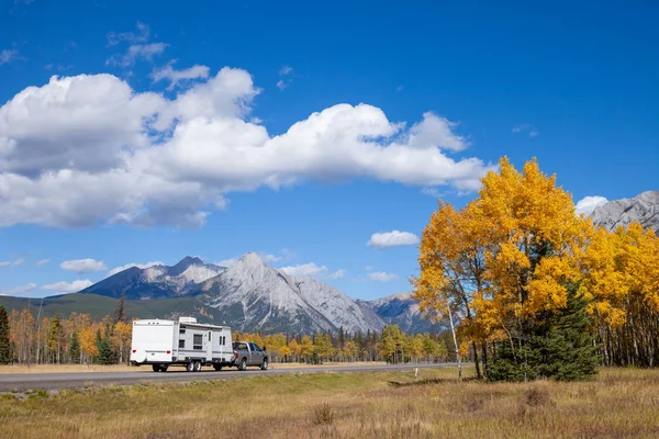 Un RV aon la carretera a través de las montañas rocosas canadienses en Kananaskis, Alberta durante el pico de los colores de otoño —  Fotos de Stock