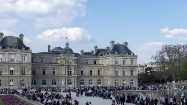 Время: люди, наслаждающиеся солнцем в саду в Париже в воскресенье — стоковое видео