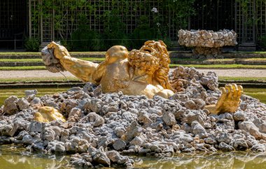 Versailles, Fransa - Temmuz 07 2020: Versay Şatosu 'nun ünlü bahçelerindeki Enceladus çeşmesine yakın çekim.