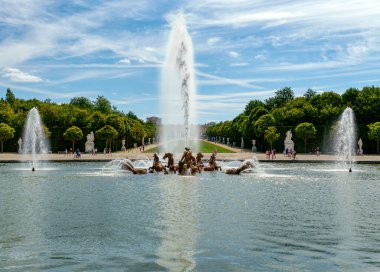 Versailles, Fransa - 02 Ağustos 2020: Versailles Bahçelerindeki Appolo Çeşmesi 'nin arka manzarası ve arka planı. Arka planda kimliği belirsiz ziyaretçiler.
