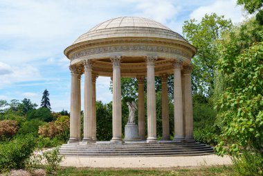 Versailles, Fransa - 02 Ağustos 2020: Versailles Sarayı, Petit Trianon bahçesi - Cupidon heykeli ile aşk tapınağı