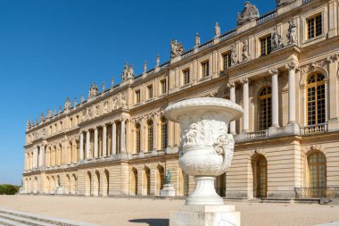 Versailles, Fransa - 22 Eylül 2020: Versailles sarayı cephesi ön planda büyük bir taş vazo ile