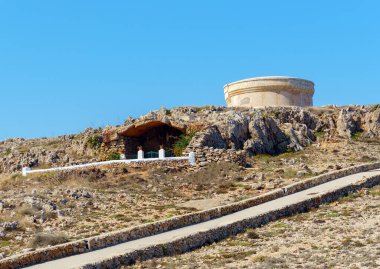 Ermita de Lourdes (diğer adıyla Ermita de la Madre de Dios de Lourdes) Fornells savunma kulesinin önünde - Menorca, Balearic adaları, İspanya