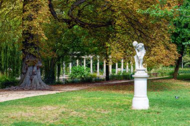 Parc Monceau 'da Alfred Lenoir' in (1850-1920) ünlü klasik Roma sütununun bulunduğu heykel Le joueur de billes (mermer oyuncu) arka planda Paris, Fransa
