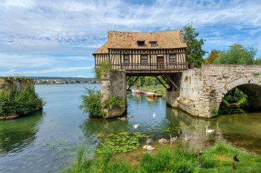 Vernon Köprüsü 'ndeki eski değirmen (le veux moulin) ön planda kuğular olan Vernon nehri üzerindeki Vernon, Normandiya, Fransa