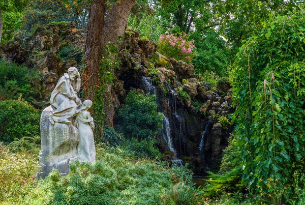 Alexandre Falguiere 'in Parc Monceau' daki Ambroise Thomas anıtı (1831-1900) ve arka planda bir şelale - Paris, Fransa