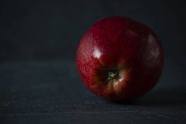 Roter Apfel vor schwarzem Steinhintergrund mit Platz für Text — Stockfoto