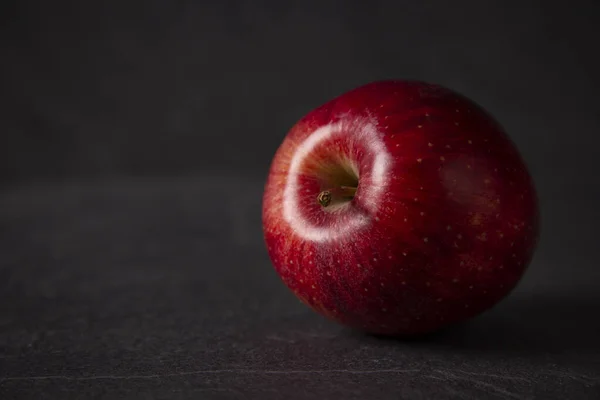 Червоне яблуко на фоні чорного каменю з простором для тексту Стокове Фото