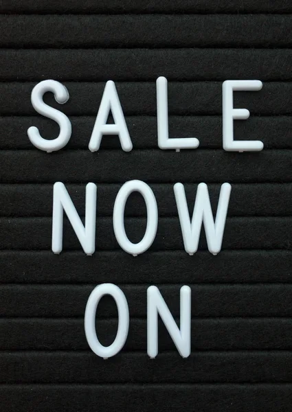 Die Worte Sale Now Weißen Plastikbuchstaben Auf Einer Schwarzen Buchstabentafel — Stockfoto