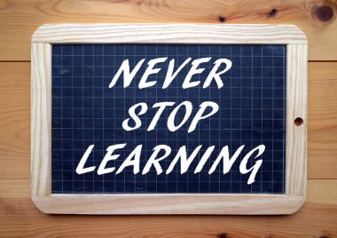 Ifade asla durdurmak öğrenme ile öğrenimlerine devam için bir hatırlatma olarak bir kara tahta üzerinde beyaz metin