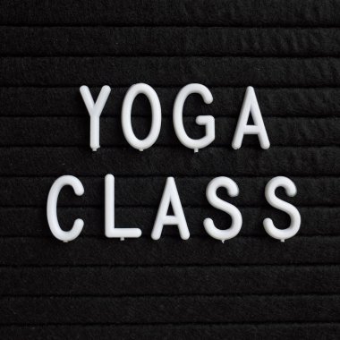 Fiziksel sağlık dikkat çekmek için bir hatırlatma olarak bir siyah harf tahtada beyaz plastik harflerle Yoga sınıf kelimeleri